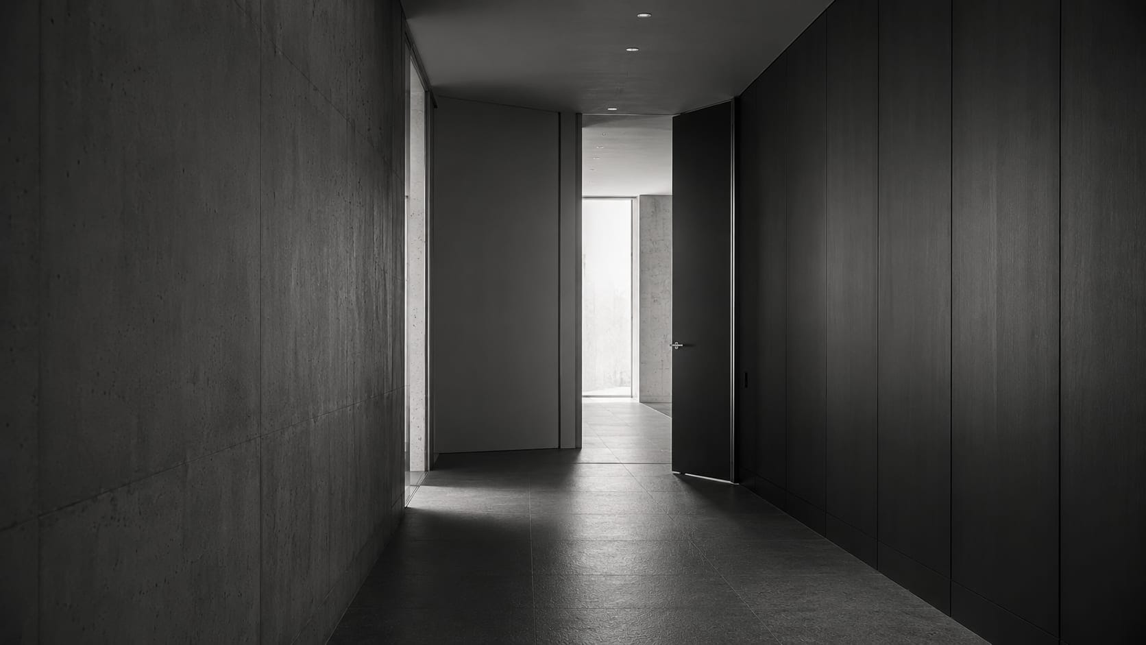 Dunkler architektonischer Korridor mit halb geöffneter Türe und Lichtwechsel im Hintergrund